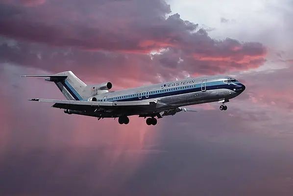 Commercial airplane flying against a dramatic sunset sky.