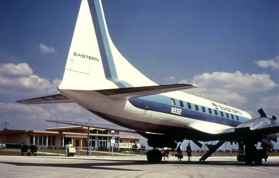 A close-up of a plane's tail and wing at an airport.