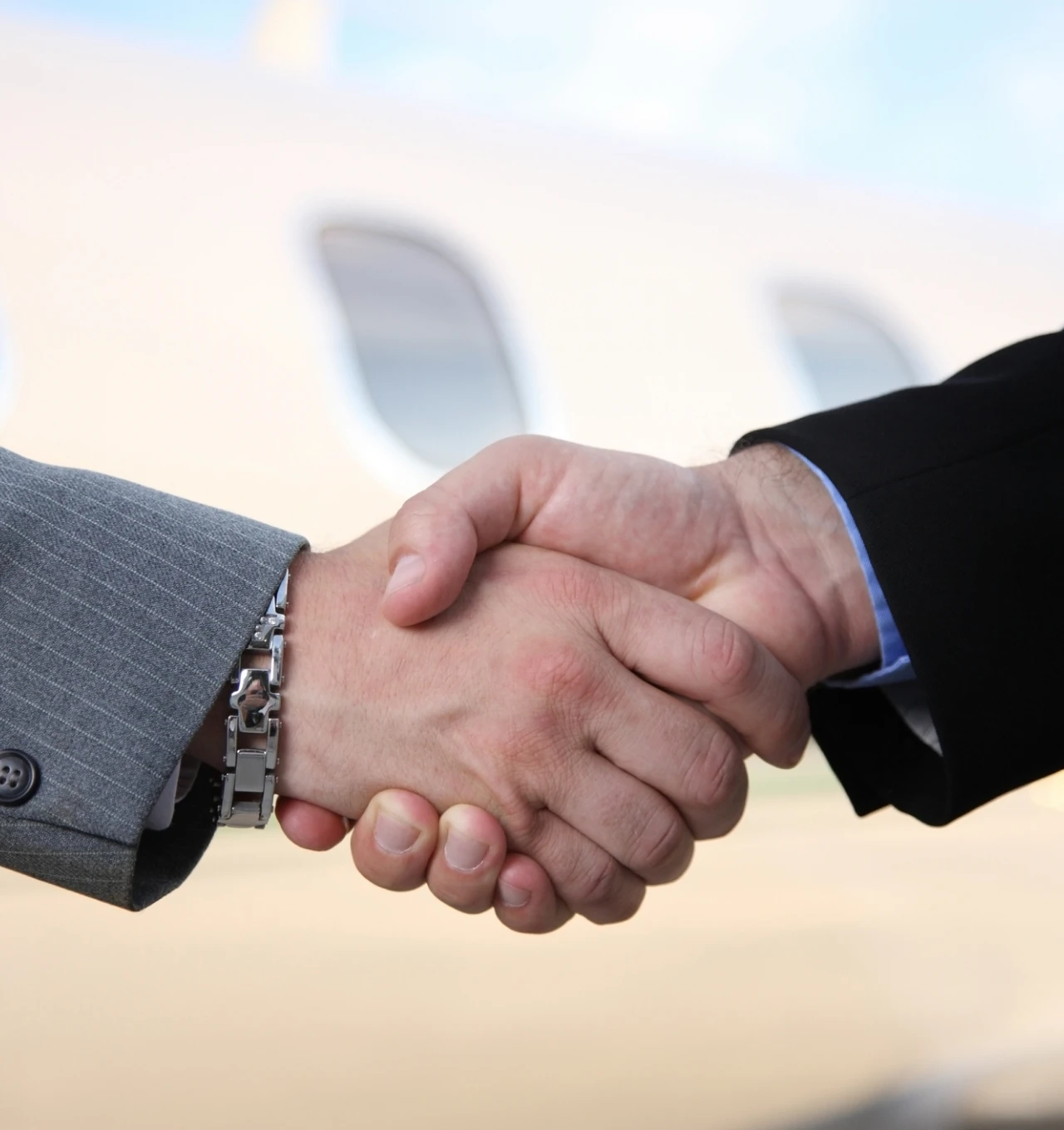 Two people shaking hands outdoors