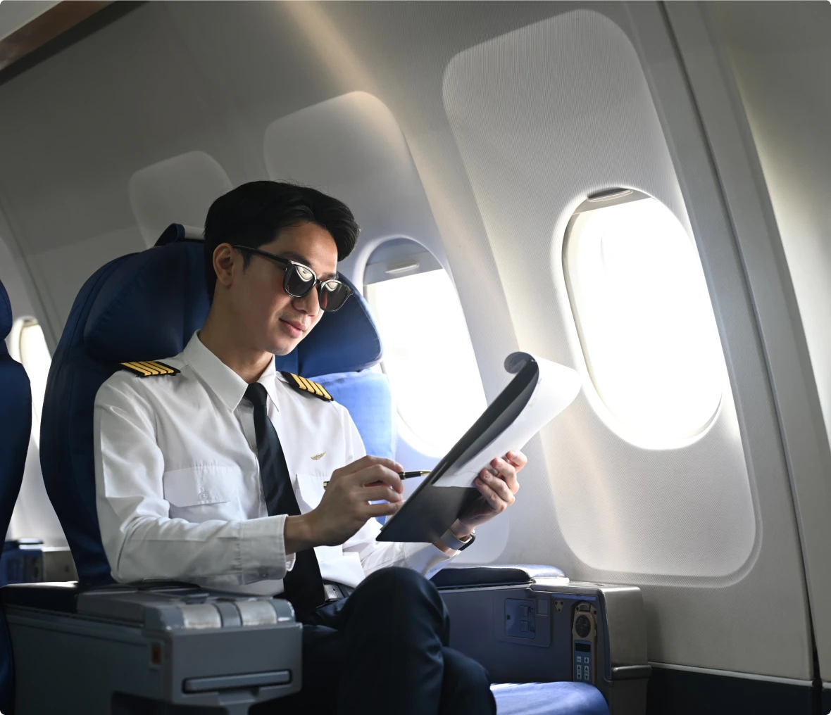 Captain in uniform studying in airplane seat